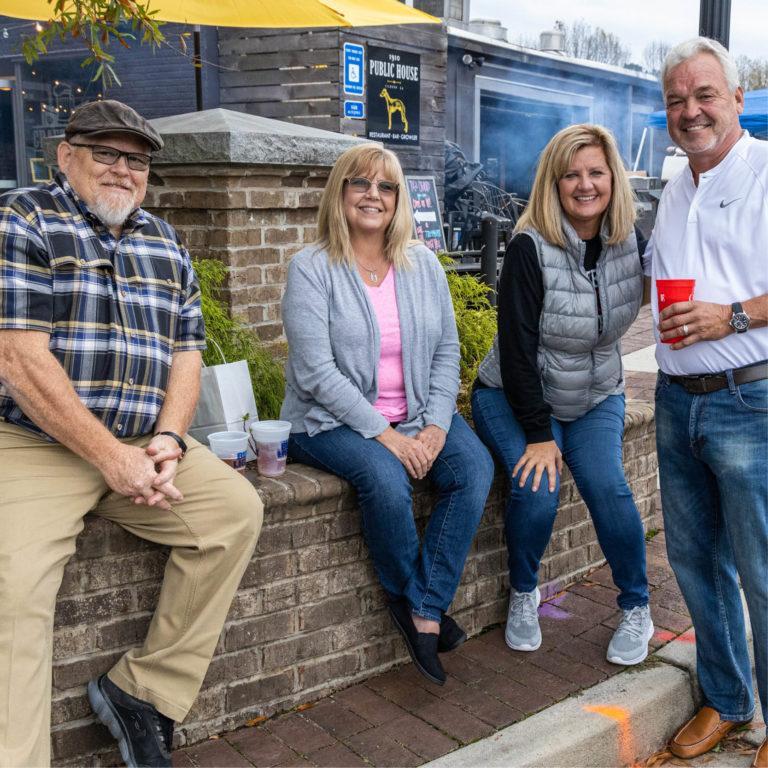 people sitting on brick wall in front of Public House